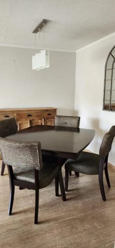 uma sala de jantar com uma mesa preta e cadeiras em Dpto Vita3 2D2B Puerto Varas em Puerto Varas