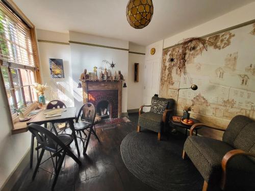 a living room with a table and chairs and a fireplace at Aviemore Rye in Rye