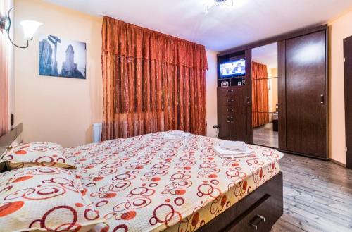 a bedroom with a bed and a television in it at Tampa Holiday Vila in Braşov