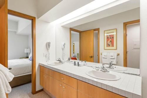a bathroom with two sinks and a large mirror at One Bedroom #202 in Olympic Valley