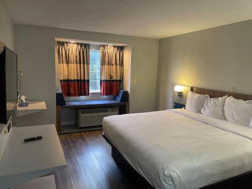 a hotel room with a bed and a window at Microtel Inn by Wyndham Atlanta Airport in Atlanta