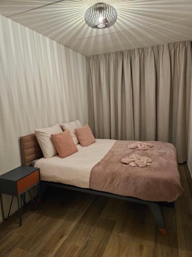 a bedroom with a bed with a chandelier at Tuinen van Genta - Breda City in Breda