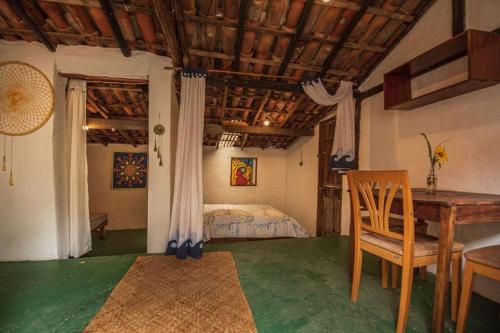 a bedroom with a bed and a table and a desk at Casinha privativa sem suíte. in Vale do Capao