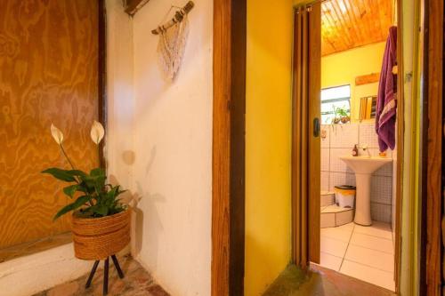 a bathroom with a toilet and a sink and a doorway at Casinha privativa sem suíte. in Vale do Capao