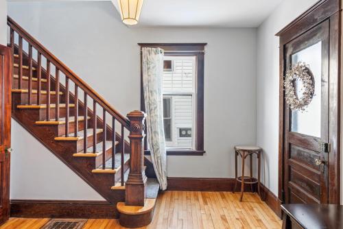 a wooden staircase in a room with a window at Beautiful Victorian Home Located Downtown Moncton in Moncton