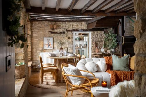 a living room with a couch and a table at Bourton Scandi Chic Authentic Cottage in Bourton on the Water