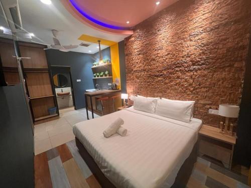 1 dormitorio con cama y pared de ladrillo en Smile Hotel Wangsa Maju, en Kuala Lumpur