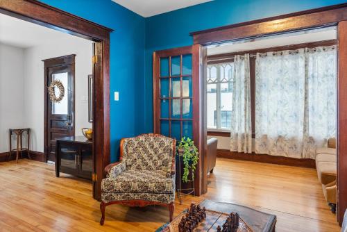 a living room with blue walls and a chair at Beautiful Victorian Home Located Downtown Moncton in Moncton