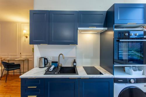 a kitchen with blue cabinets and a sink at L Amiens Haussmann-Gare-Hortillonnages-Centre-ville-WIFI in Amiens