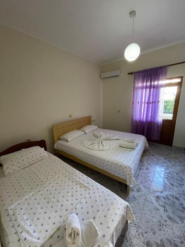 a bedroom with two beds and a window at Villa Festim Ksamil in Ksamil
