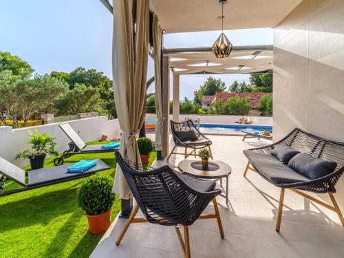 an outdoor patio with chairs and a table at Holiday Home Villa Renesansa by Interhome in Milna