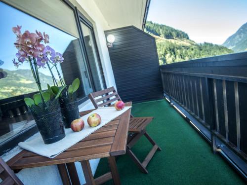 a table with apples and flowers on a balcony at Apartment Landhaus St- Georg-4 by Interhome in Bad Gastein
