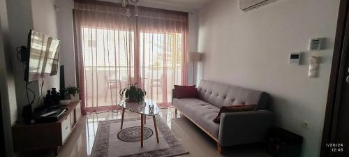 a living room with a couch and a large window at EZITH LUXURY APARTMENTS in Heraklio Town