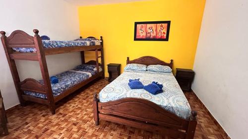 a bedroom with two bunk beds and a yellow wall at Complejo Sol Palmeras in Mar de Ajó