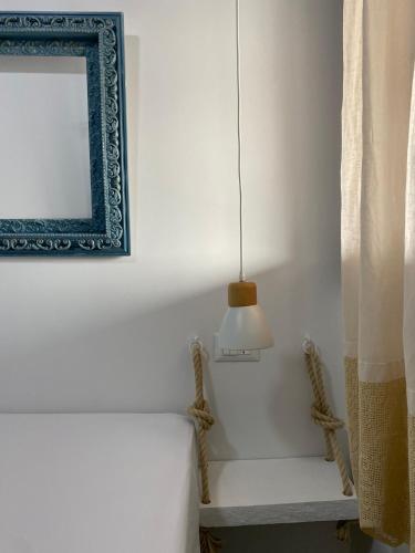 a room with a bed and a mirror and a lamp at Lavender farm house in Nafpaktos