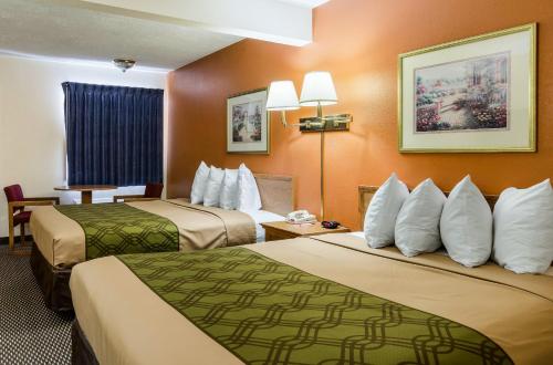 Quality Inn & Suites في سيوكس سيتي: غرفة فندق بسريرين بجدران برتقالية
