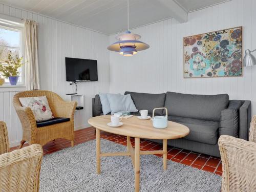 a living room with a couch and a table at Holiday Home Asgot - 15m from the sea in Bornholm by Interhome in Hasle