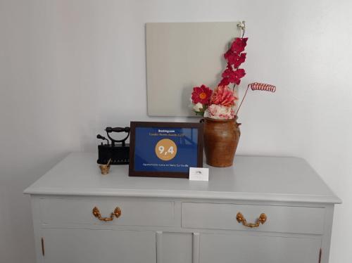 a tv sitting on top of a dresser with a vase of flowers at Apartamento completo en Sierra Sur in Villanueva de San Juan