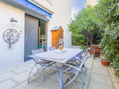une table et des chaises assises sur une terrasse dans l'établissement Apartment Terrasses de la Baie des Anges by Interhome, à Nice