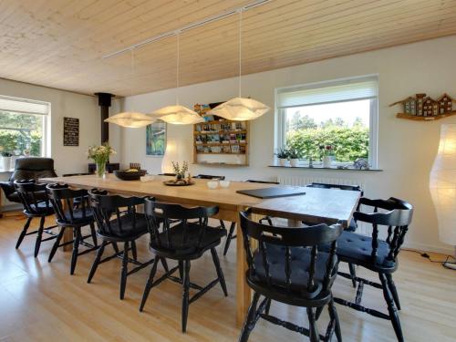 a dining room with a large wooden table and chairs at Holiday Home Lavrans - 2-5km from the sea in Western Jutland by Interhome in Henne Strand