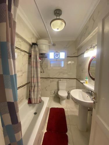 une salle de bain avec une baignoire, des toilettes et un lavabo dans l'établissement Elegant and Spacious Luxury Apartment in Al Rehab gated community, New Cairo, au Caire