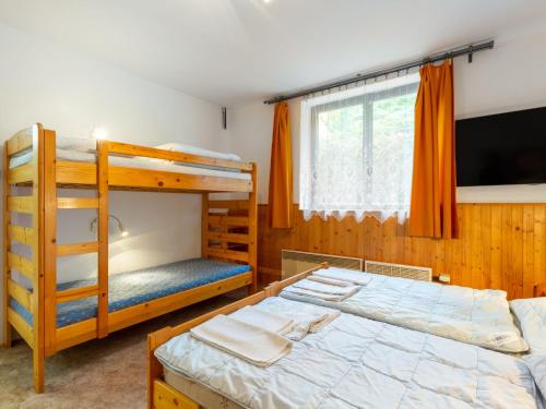 a bedroom with two bunk beds and a flat screen tv at Holiday Home Malovidy by Interhome in Rataje nad Sázavou
