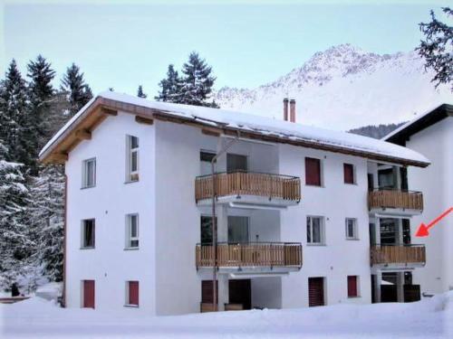 a white building with a balcony in the snow at Apartment Auarara by Interhome in Lenzerheide