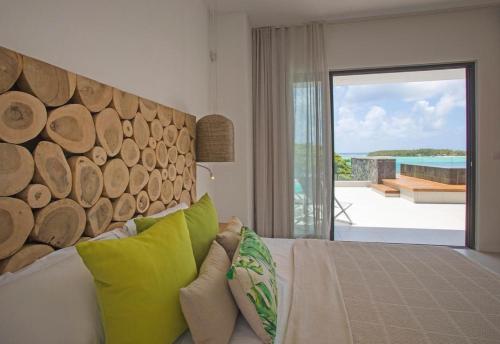 a living room with a couch with a wooden headboard at PentHouse sur mer - Blue Alizée in Blue Bay