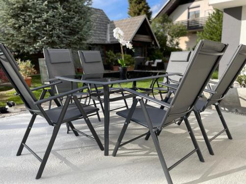 a group of chairs around a glass table at Green Oasis Garden in Šenčur