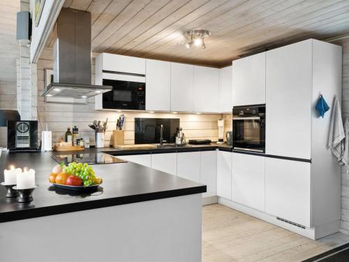 een keuken met witte kasten en een fruitschaal op een aanrecht bij Holiday Home Anemarie - all inclusive - 400m from the sea by Interhome in Karrebæksminde