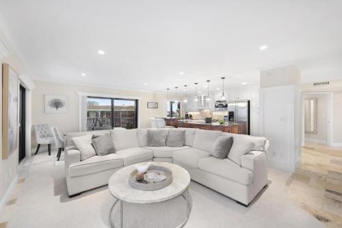 a living room with a white couch and a table at Breath-taking waterfront condo with pool/spa/tennis in Marco Island