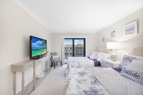a white room with two beds and a tv at Breath-taking waterfront condo with pool/spa/tennis in Marco Island