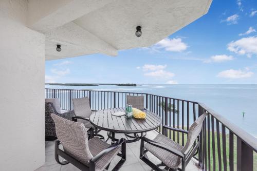 a balcony with a table and chairs and the ocean at Breath-taking waterfront condo with pool/spa/tennis in Marco Island