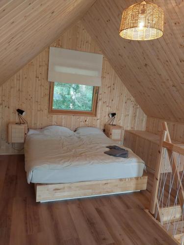 a bedroom with a bed in a wooden cabin at Strefa ciszy Lubomin 