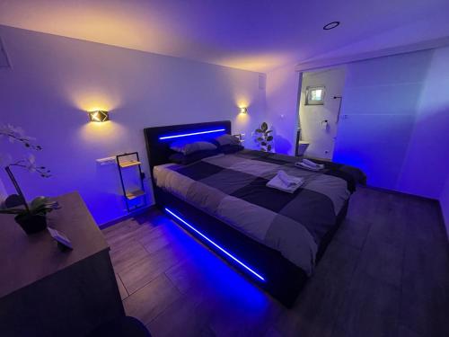 a bedroom with a large bed with blue lights at Green Oasis Garden in Šenčur