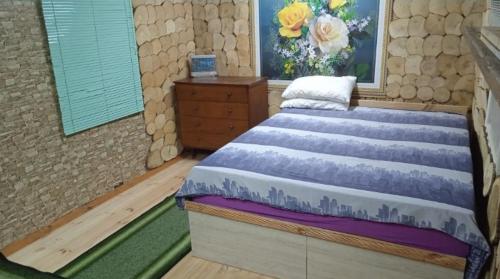 Schlafzimmer mit einem Bett mit Wandgemälde in der Unterkunft Дача, будинок,баня in Leplyavo
