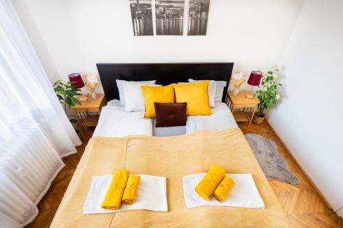 a bedroom with a bed with yellow pillows on it at Cozy Panorama Apartment next to the Buda Castle in Budapest
