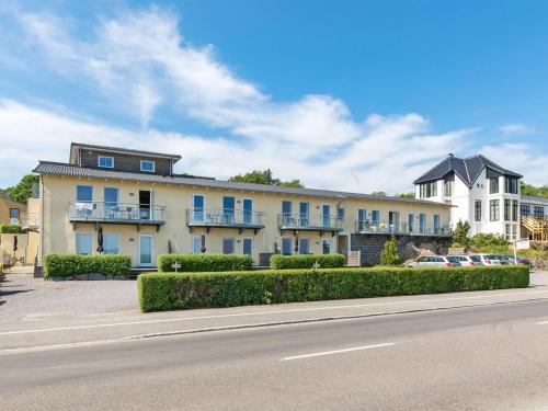 a large white building with blue windows and a street at Apartment Henna - 50m from the sea in Bornholm by Interhome in Allinge