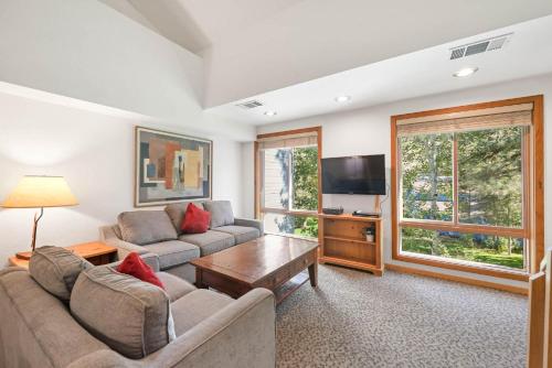 a living room with a couch and a tv at Palisades Tahoe Lodge Rentals Studio Loft #306 in Olympic Valley