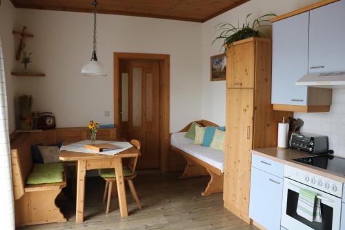 eine kleine Küche mit einem Tisch und einem Sofa in der Unterkunft Bio-Bauernhof Haunschmid in Ardagger Markt
