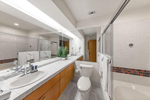 a bathroom with a toilet and a sink and a tub at Palisades Tahoe Lodge Rentals Studio Loft #308 in Olympic Valley