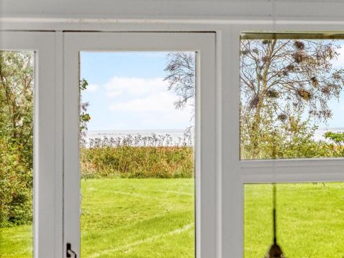 uma janela aberta com vista para um campo em Holiday Home Majvor - 200m from the sea in NE Jutland by Interhome em Hadsund