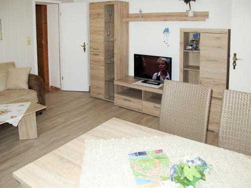 een woonkamer met een tafel en een tv in een kamer bij Apartment Kristin by Interhome in Zinnowitz