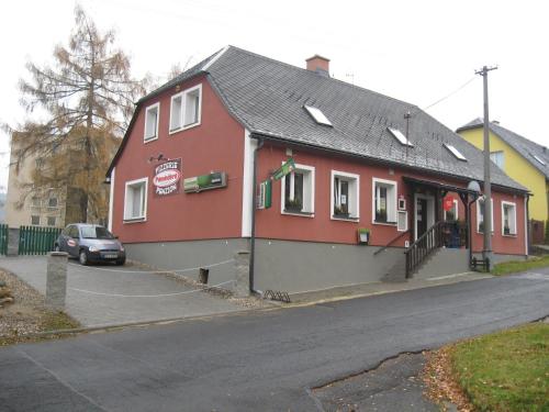 a red building on the side of a street at Penzion Pomodoro in Vrbno pod Pradědem