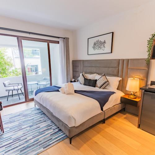 a bedroom with a large bed and a balcony at Casa Castillo in Mexico City