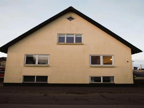 Una casa con tres ventanas en el costado. en Holiday Home Ullakarin - 200m from the sea in Western Jutland by Interhome, en Thyborøn