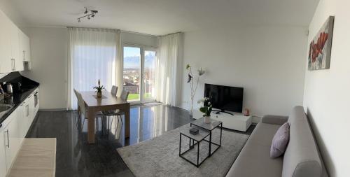 een woonkamer met een bank en een tafel bij Moderno bilocale vista lago Maggiore in Gordola