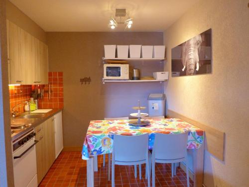 cocina con mesa con sillas y microondas en Apartment Rond-Point-6 by Interhome, en Crans-Montana