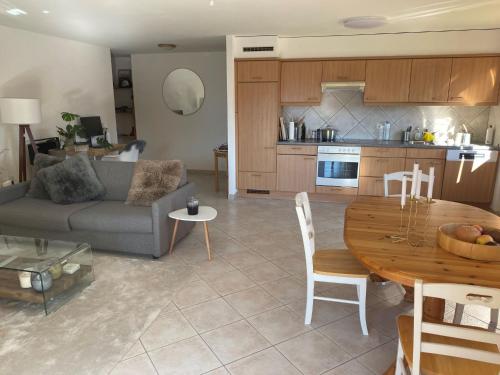 eine Küche und ein Wohnzimmer mit einem Sofa und einem Tisch in der Unterkunft Apartment Cormier 3 by Interhome in Ovronnaz