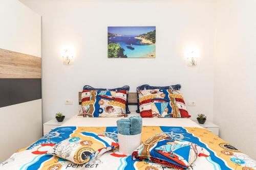 um quarto com 2 camas e almofadas coloridas em SUMAN APARTMENT WITH SHARED SWIMMING POOL, 120m FROM THE BEACH em Kaštela